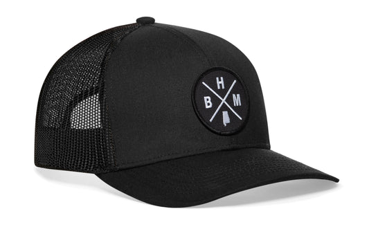 Black trucker hat viewed from the right side, showcasing a Birmingham BHM X Embroidered Black Circle Patch prominently displayed on the front