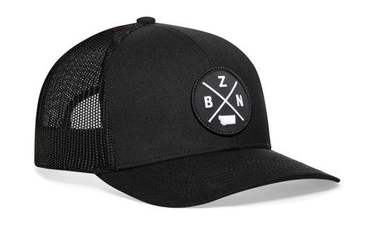 Black trucker hat viewed from the right side, showcasing a Bozeman BZN X Embroidered Circle Patch prominently displayed on the front