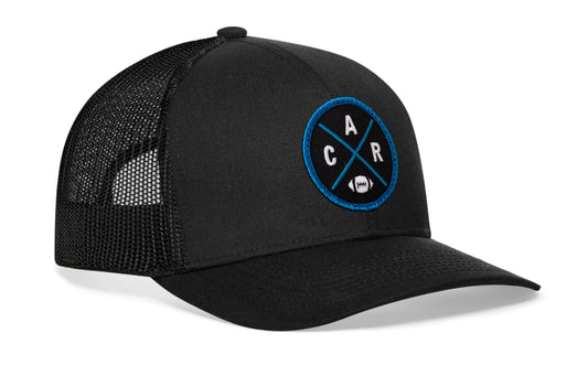 black trucker hat viewed from the right side, showcasing a CAR Football embroidered X patch in Carolina blue and black prominently displayed on the front