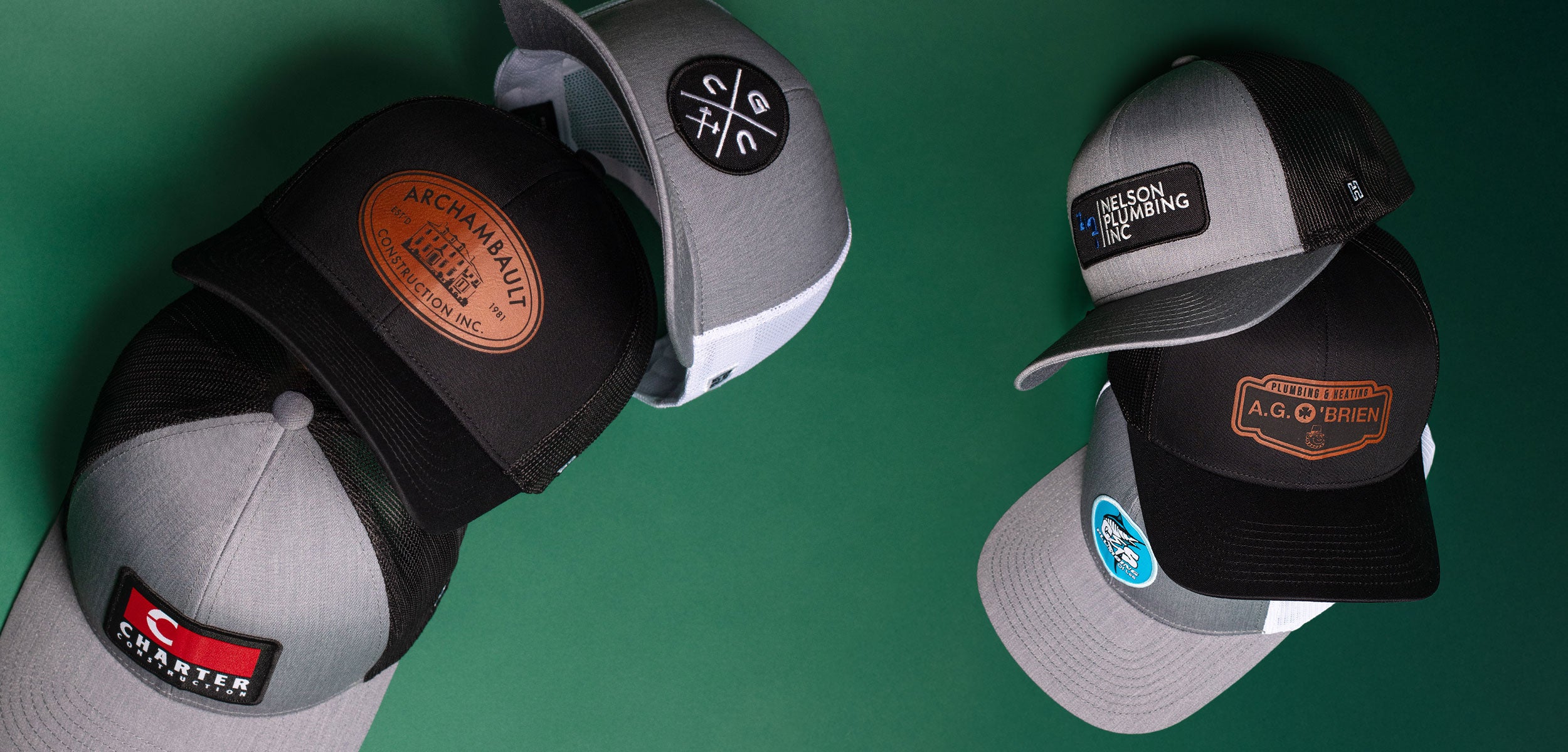 Haka Trucker hats in various colors ranging from black to gray and black showcasing custom brand logos on a green background