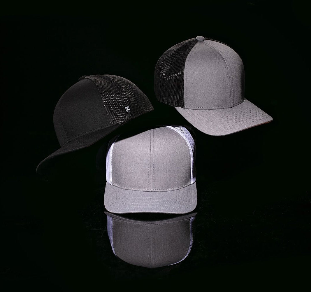 Haka Blank Trucker Hats in Black, Gray-White, Grey-Black. Haka H shows prominently on left side of one hat.