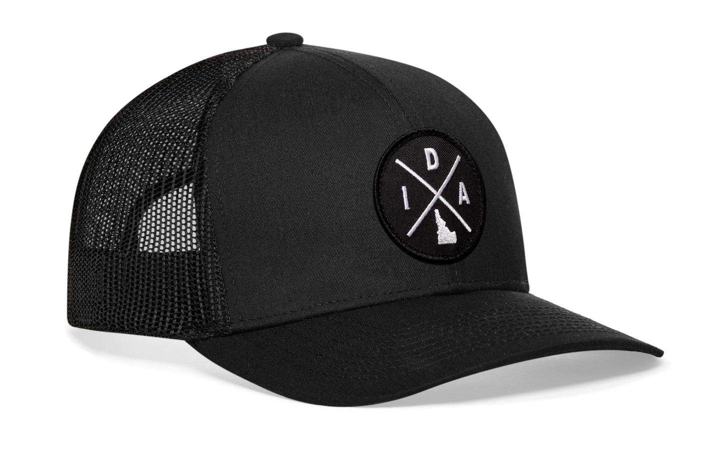 Black trucker hat viewed from the right side, showcasing a Idaho IDA X Embroidered Circle Patch prominently displayed on the front