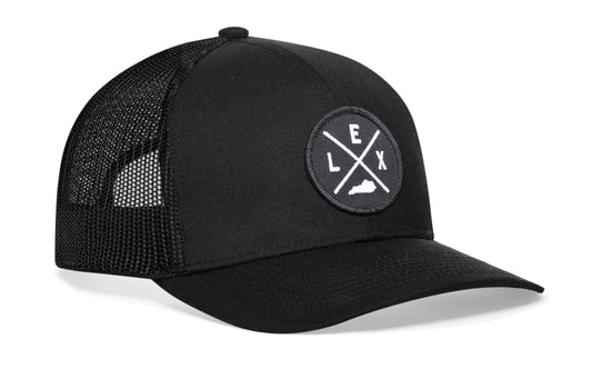 Black trucker hat viewed from the right side, showcasing a Lexington LEX X Embroidered Circle Patch prominently displayed on the front