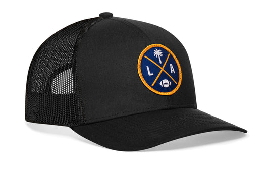 black trucker hat viewed from the right side, showcasing a LA Football embroidered X patch in blue and gold prominently displayed on the front
