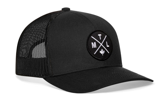 Black trucker hat viewed from the right side, showcasing a Montreal MTL X Embroidered Circle Patch prominently displayed on the front