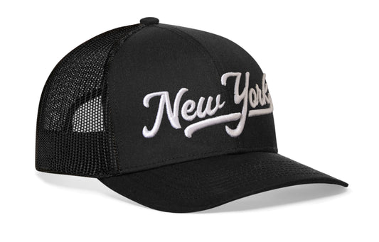 black trucker hat viewed from the right side, showcasing a White 'New York' Puff Script 3D Embroidery prominently displayed on the front
