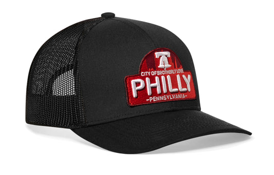 black trucker hat viewed from the right side, showcasing a Cityscape 3D embroidery cut-to-shape patch prominently displayed on the front