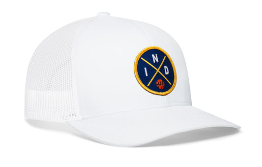 white trucker hat viewed from the right side, showcasing a navy and gold basketball embroidered X patch prominently displayed on the front