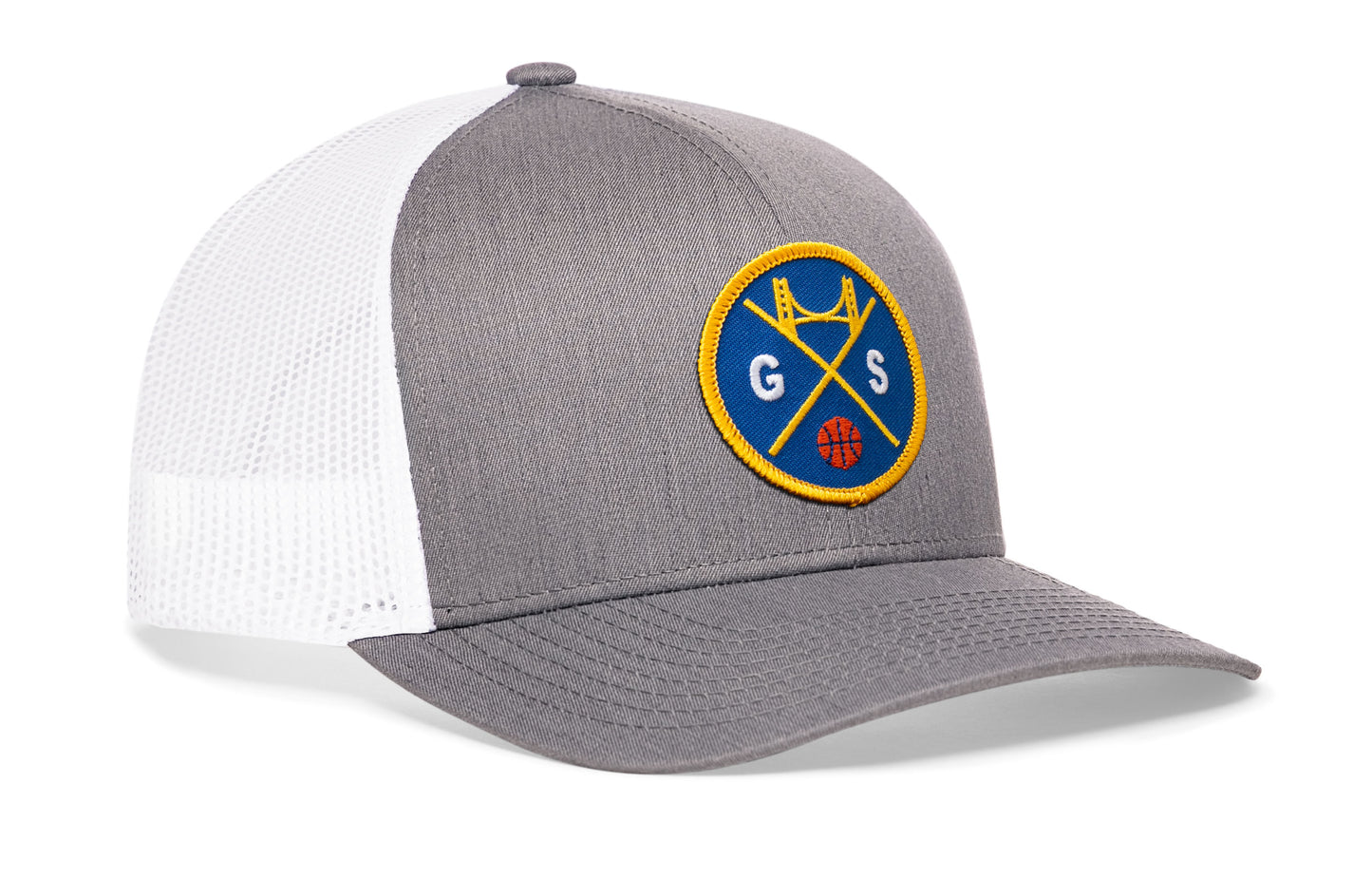 gray-white trucker hat viewed from the right side, showcasing a bold navy and gold embroidered X patch prominently displayed on the front