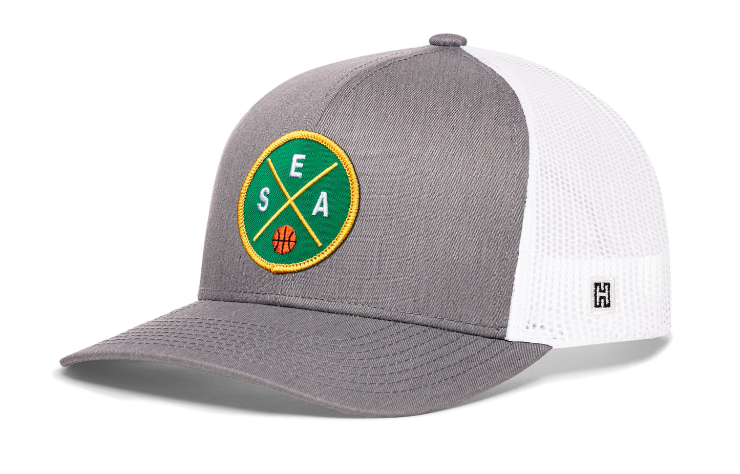 Seattle trucker hat, gray-white snapback showing Haka brandmark on left side mesh.
Rep Seattle, WA.