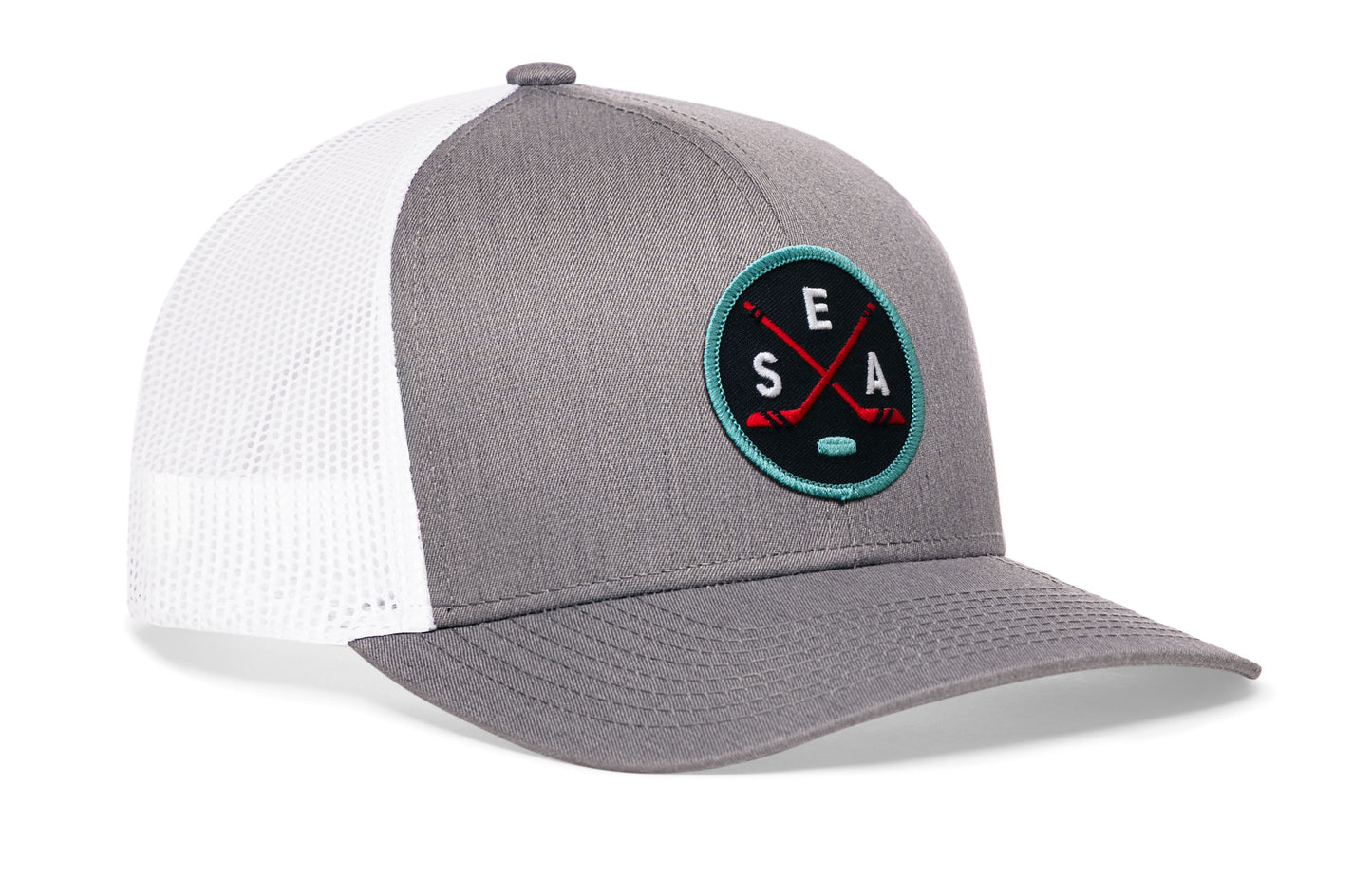 gray-white trucker hat viewed from the right side, showcasing a bold navy, red and columbia blue embroidered X patch prominently displayed on the front