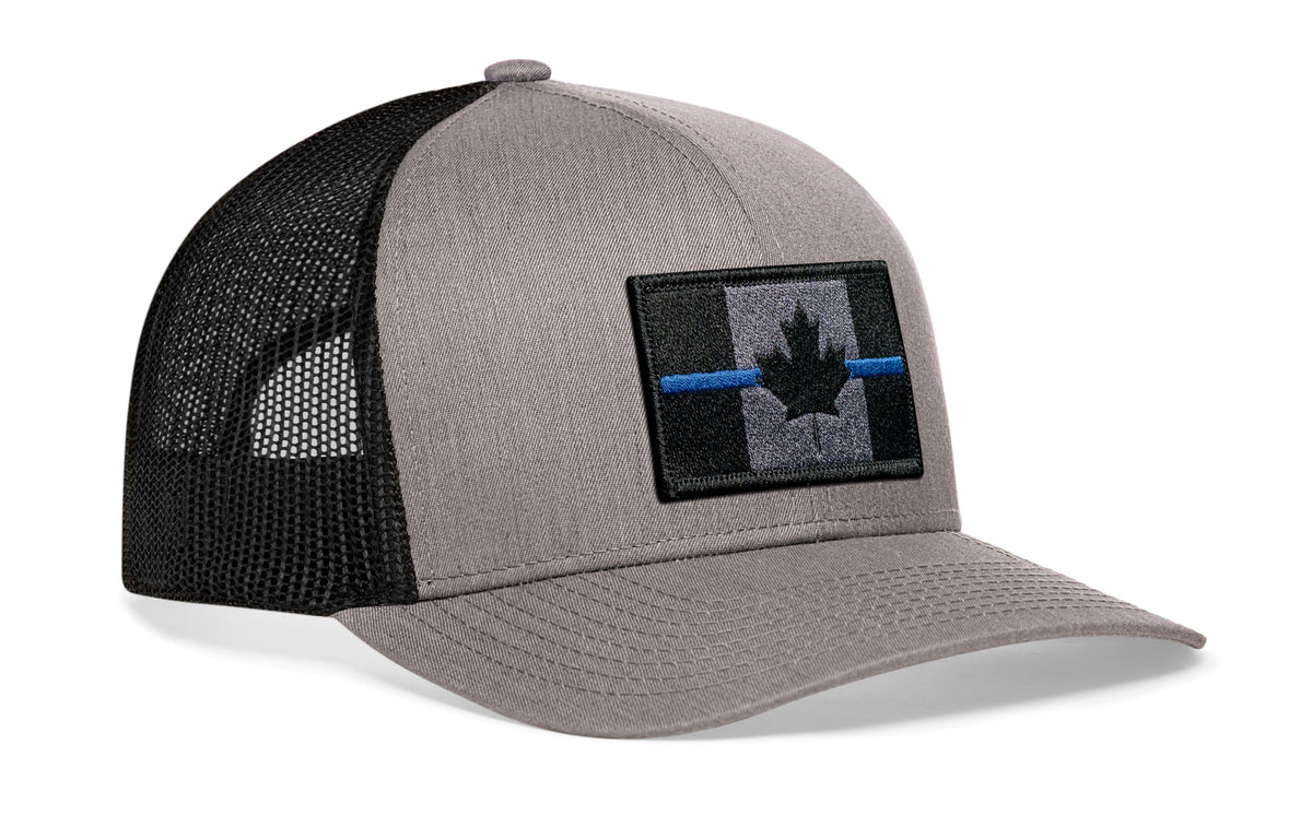 gray-black trucker hat viewed from the right side, showcasing a Canadian maple leaf tactical bold blue, gray and black embroidered flag patch prominently displayed on the front