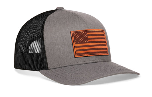 Gray/Black trucker hat viewed from the right side, showcasing a American Flag Embroidered Rectangle Patch prominently displayed on the front
