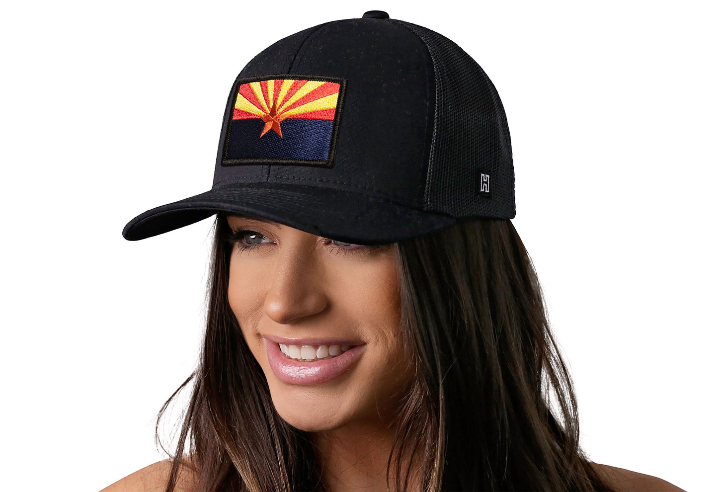 Black trucker hat worn by a female model viewed from the left side and features a Arizona Flag Embroidered Rectangle Patch displayed on the front panel. The hat has a classic mesh back design and a curved structured bill