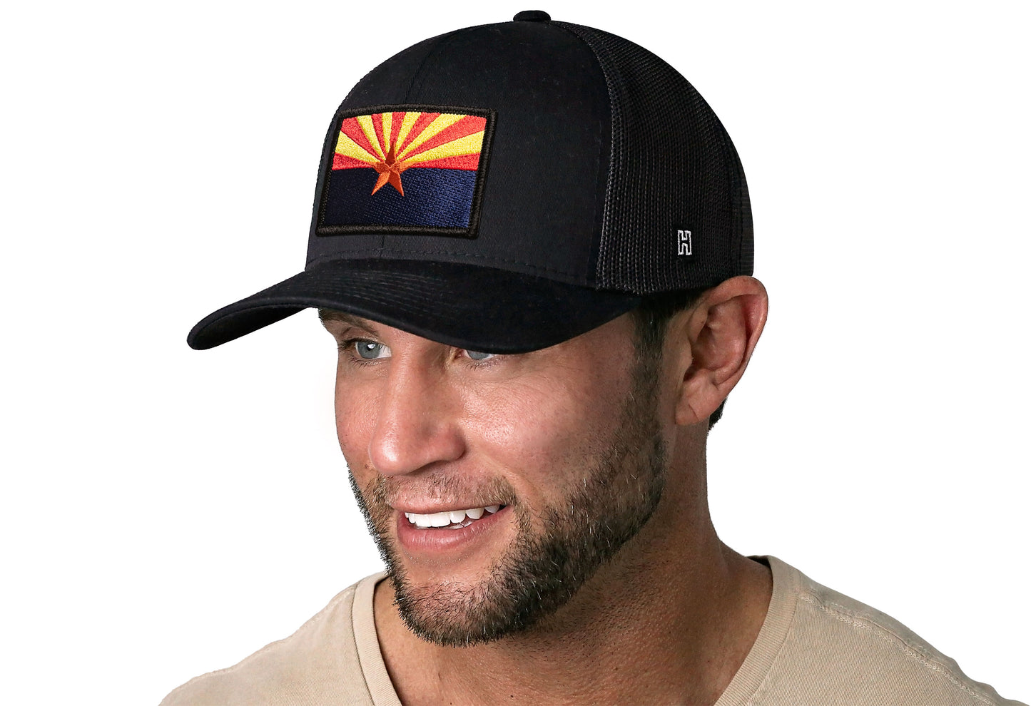 Black trucker hat worn by a male model viewed from the left side and features a Arizona Flag Embroidered Rectangle Patch displayed on the front panel. The hat has a classic mesh back design and a curved structured bill