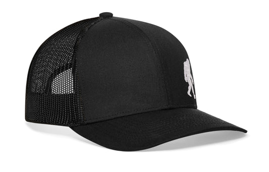 Black trucker hat viewed from the right side, showcasing a Bigfoot Black Sasquatch Flat Embroidery prominently displayed on the front