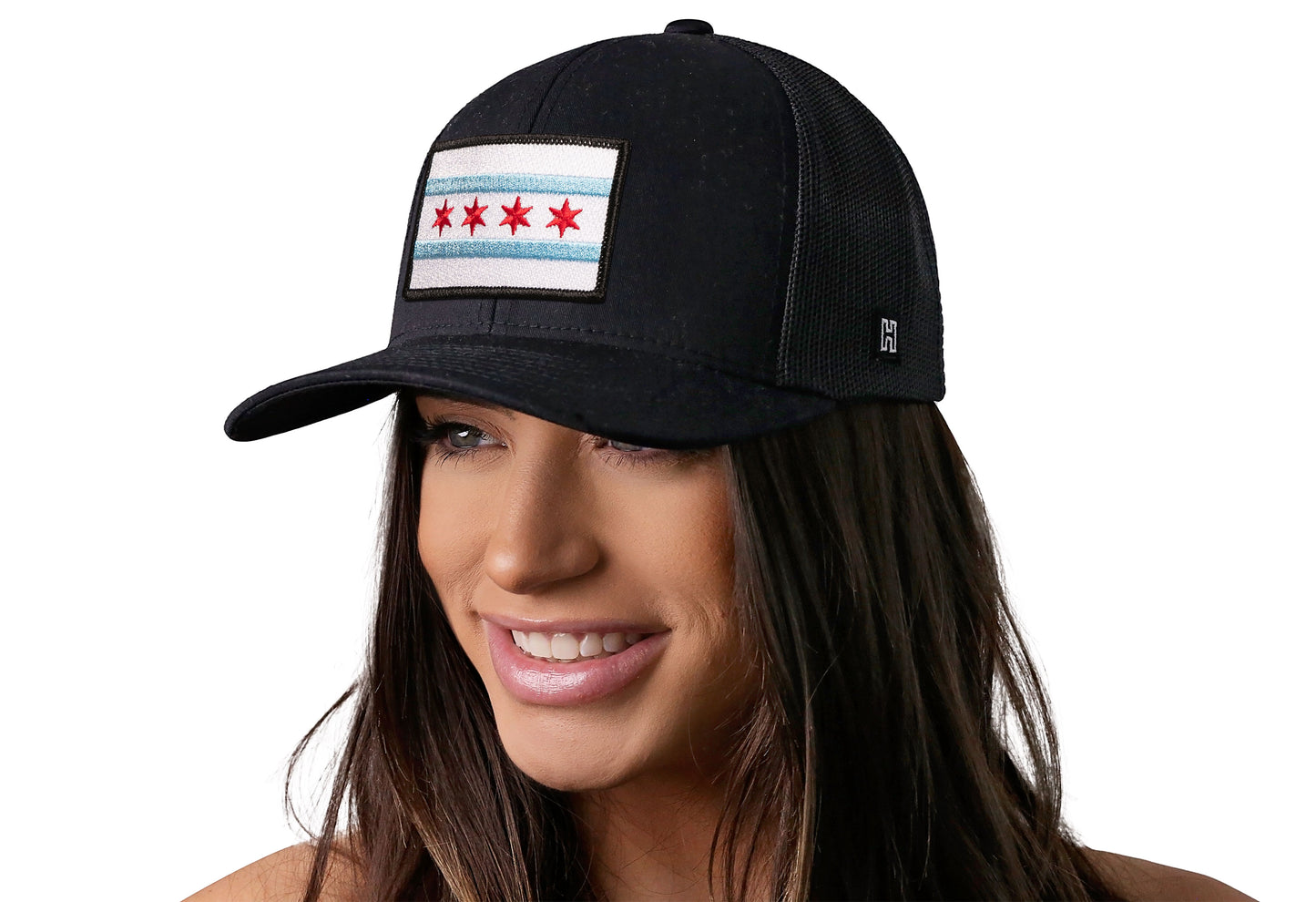 Black trucker hat worn by a female model viewed from the left side and features a Chicago Flag Embroidered Rectangle Patch displayed on the front panel. The hat has a classic mesh back design and a curved structured bill