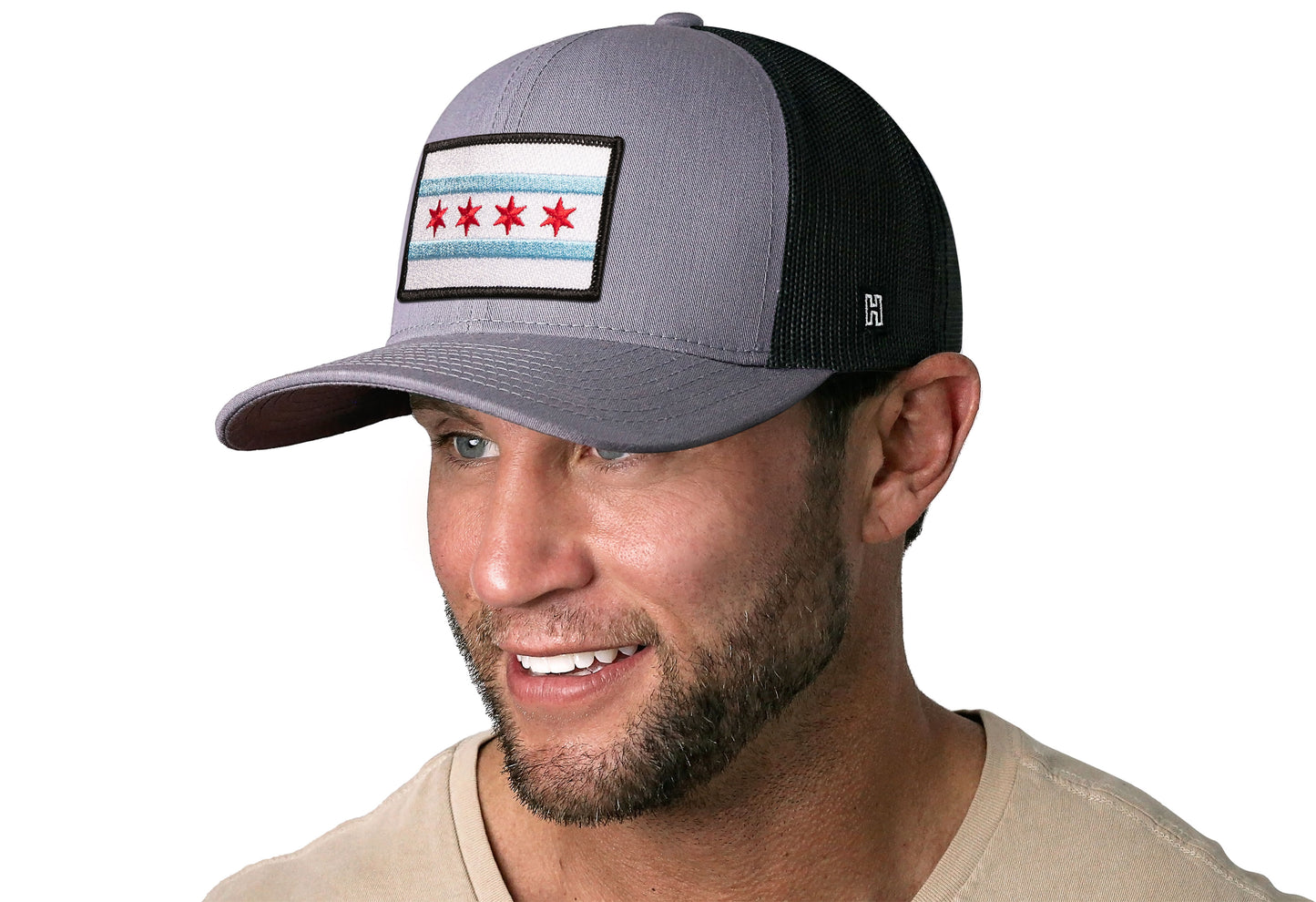 Gray-Black trucker hat worn by a male model viewed from the left side and features a Chicago Flag Embroidered Rectangle Patch displayed on the front panel. The hat has a classic mesh back design and a curved structured bill