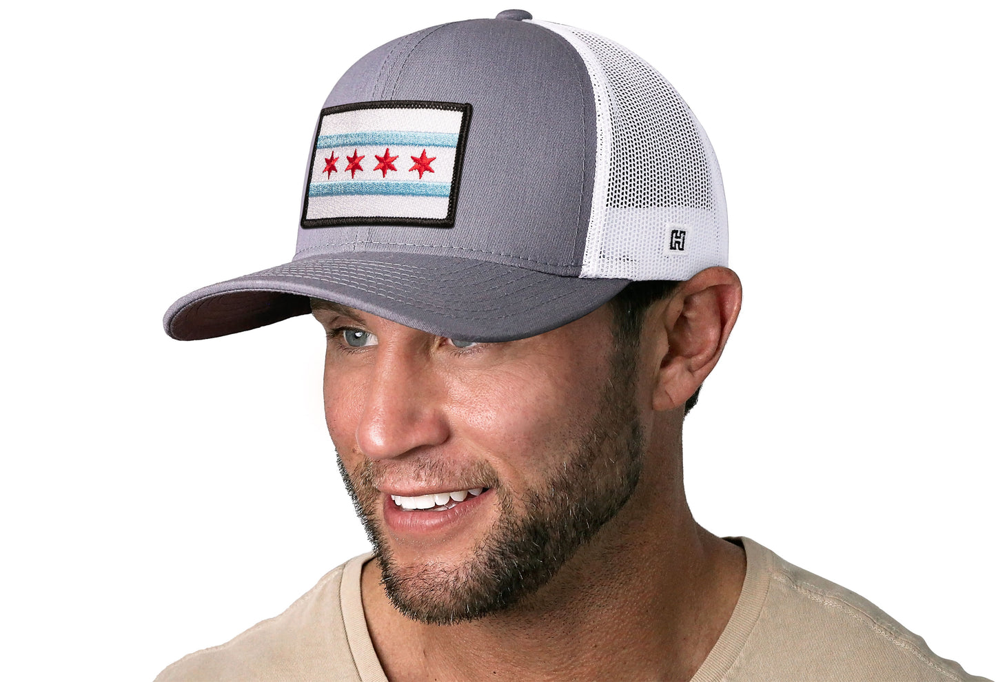 Gray-White trucker hat worn by a male model viewed from the left side and features a Chicago Flag Embroidered Rectangle Patch displayed on the front panel. The hat has a classic mesh back design and a curved structured bill