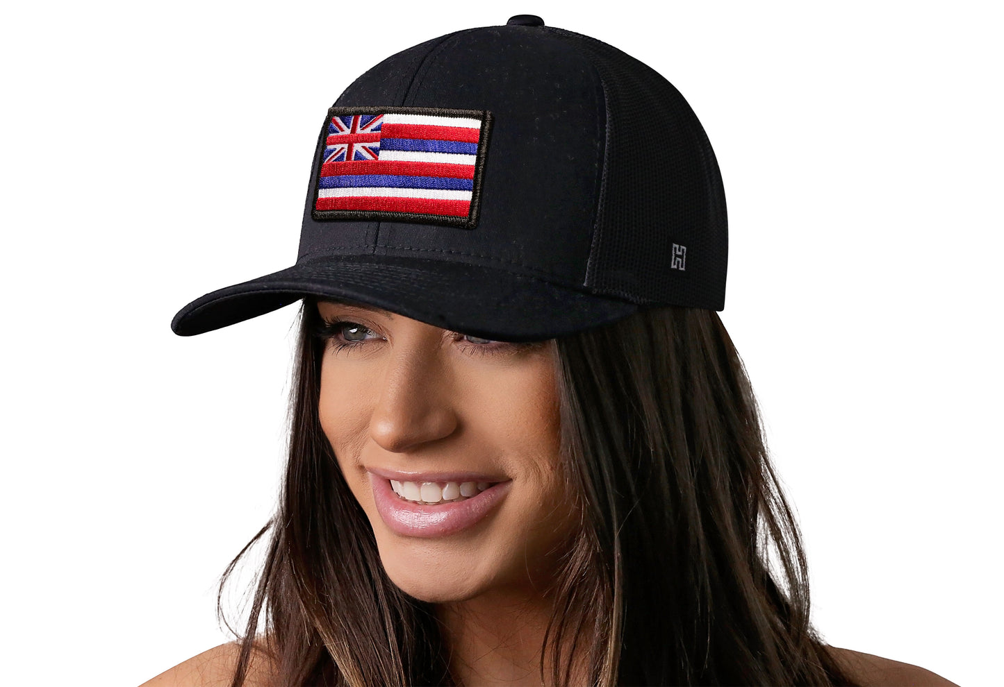 Black trucker hat worn by a female model viewed from the left side and features a Hawaii Embroidered Rectangle Patch displayed on the front panel. The hat has a classic mesh back design and a curved structured bill