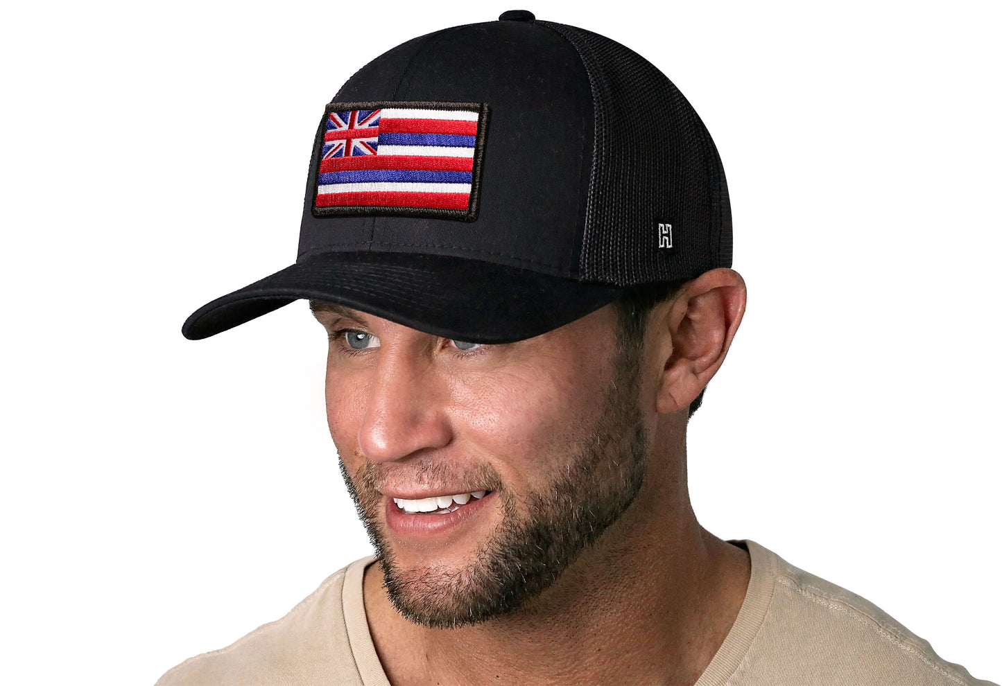 Black trucker hat worn by a male model viewed from the left side and features a Hawaii Embroidered Rectangle Patch displayed on the front panel. The hat has a classic mesh back design and a curved structured bill