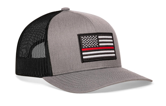 gray-black trucker hat viewed from the right side, showcasing a bold red and white embroidered patch prominently displayed on the front