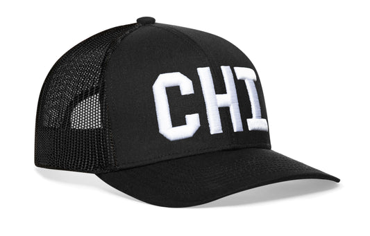 Black trucker hat viewed from the right side, showcasing a White "CHI" Puff Embroidery Block prominently displayed on the front