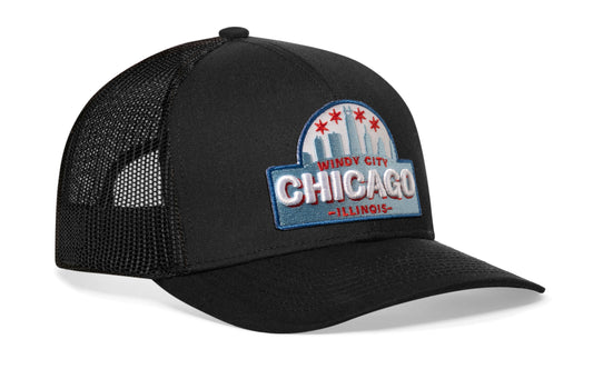 Black trucker hat viewed from the right side, showcasing a Chicago Cityscape Embroidered Patch prominently displayed on the front