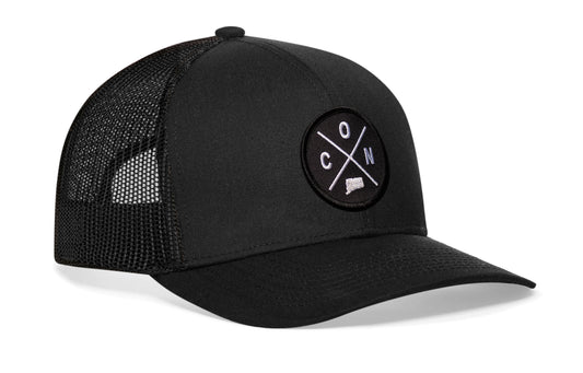 Black trucker hat viewed from the right side, showcasing a Connecticut CON X Embroidered Circle Patch prominently displayed on the front