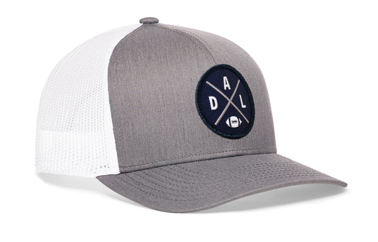 gray-white trucker hat viewed from the right side, showcasing a DAL Football embroidered X patch in navy, silver, and white prominently displayed on the front