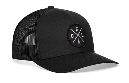 Black trucker hat viewed from the right side, showcasing a Delaware DEL X Embroidered Circle Patch prominently displayed on the front