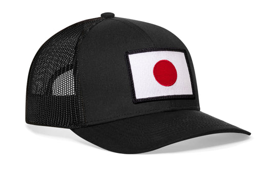 Black trucker hat viewed from the right side, showcasing a Japanese Flag Embroidered Rectangle Patch prominently displayed on the front