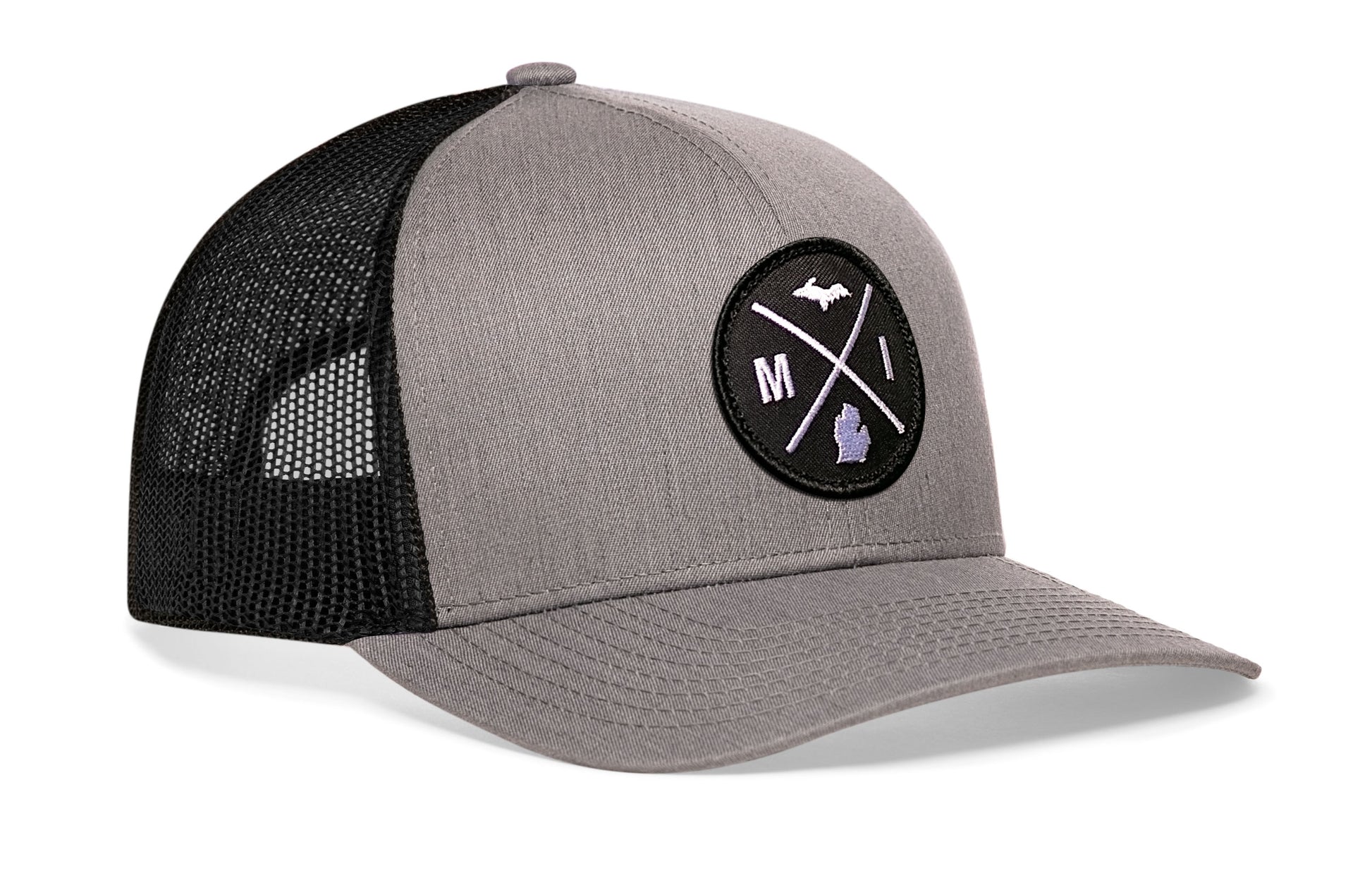 Gray-Black trucker hat viewed from the right side, showcasing a Michigan MI X Embroidered Circle Patch prominently displayed on the front