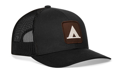 Black trucker hat viewed from the right side, showcasing a NP Campsite Pictographic Symbols Embroidered Patch prominently displayed on the front