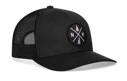 Black trucker hat viewed from the right side, showcasing a New Hampshire NH X Embroidered Circle Patch prominently displayed on the front