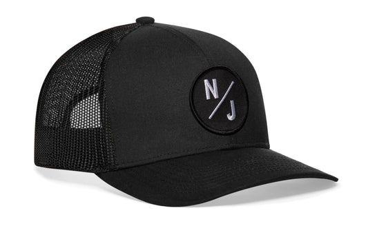 Black trucker hat viewed from the right side, showcasing a New Jersey NJ X Embroidered Circle Patch prominently displayed on the front