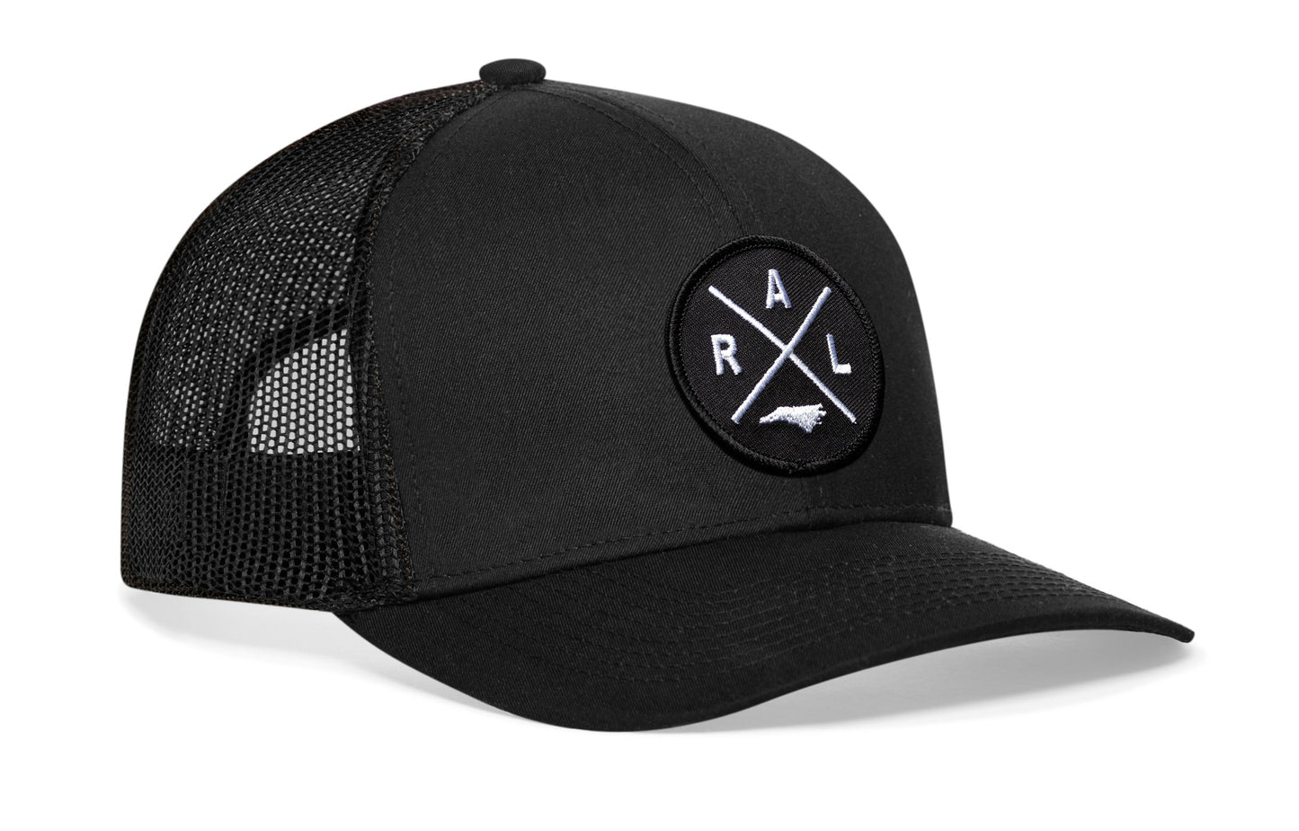 Black trucker hat viewed from the right side, showcasing a Raleigh RAL X Embroidered Circle Patch prominently displayed on the front