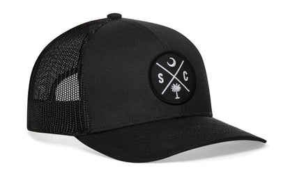 Black trucker hat viewed from the right side, showcasing a South Carolina SC Embroidered X Patch prominently displayed on the front