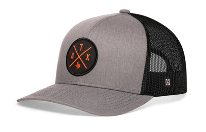 Austin Trucker Hat, gray-black snapback showing Haka brandmark on left side of cap.