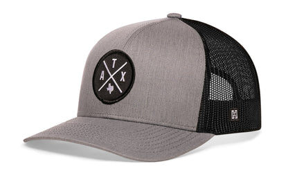 Austin Trucker Hat, gray-black snapback showing Haka brandmark on left side of cap.