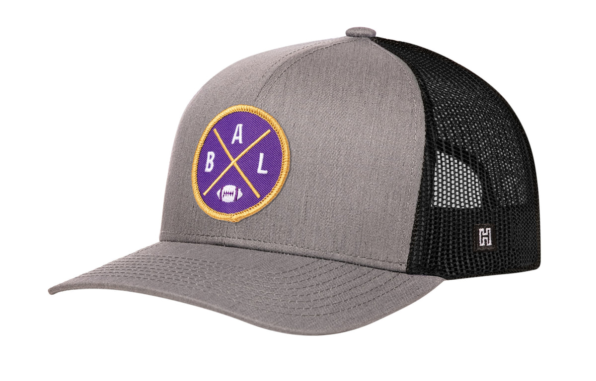 Baltimore Football Trucker Hat, gray-black snapback showing Haka brandmark on left side of cap.