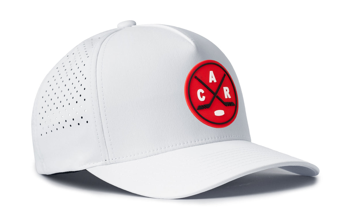white performance 5-panel hat viewed from the right side, showcasing a bold red and black pvc patch prominently displayed on the front