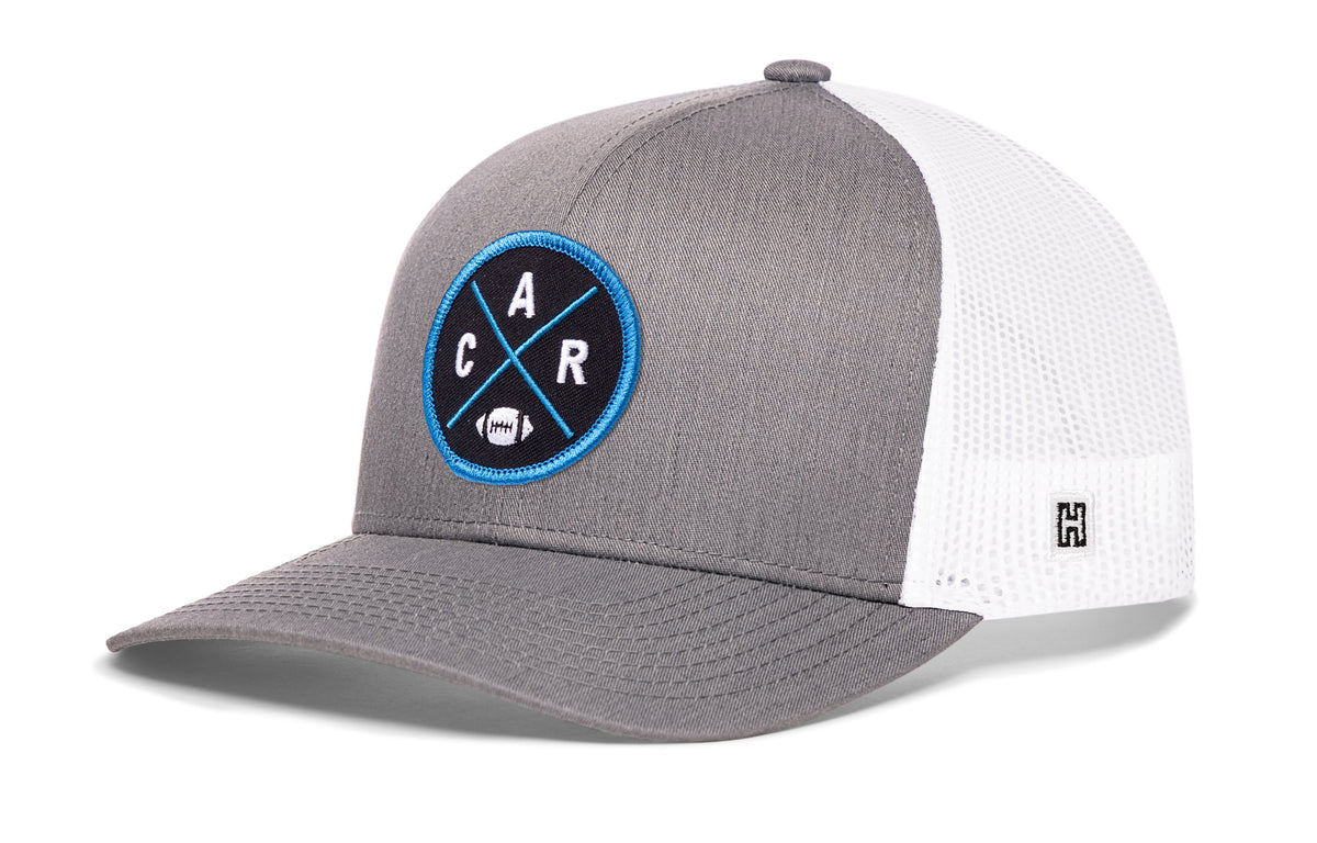 Carolina Football Trucker Hat, gray-white snapback showing Haka brandmark on left side of cap.