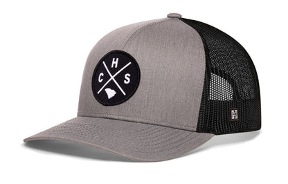 Charleston Trucker Hat, gray-black snapback showing Haka brandmark on left side of cap.