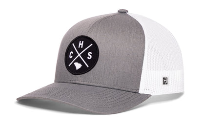Charleston Trucker Hat, gray-white snapback showing Haka brandmark on left side of cap.