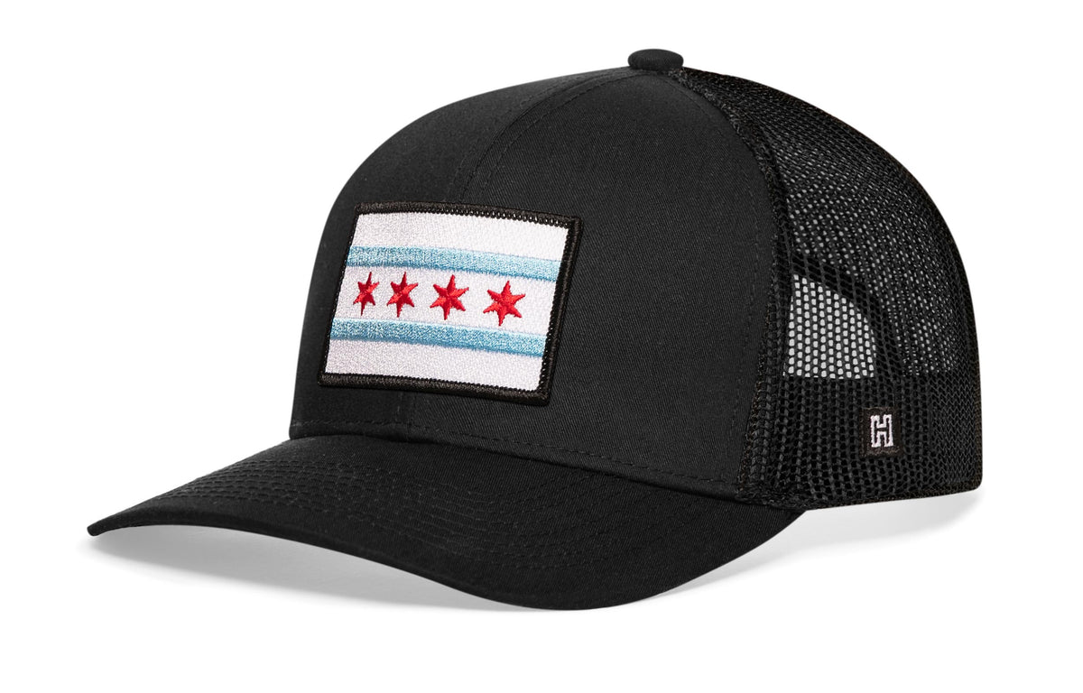 Chicago Trucker Hat, black snapback showing Haka brandmark on left side of cap.