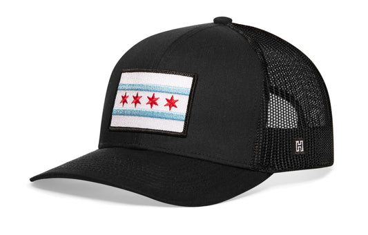 Chicago Trucker Hat, black snapback showing Haka brandmark on left side of cap.