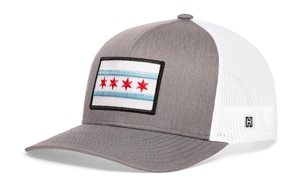 Chicago Trucker Hat, gray-white snapback showing Haka brandmark on left side of cap.