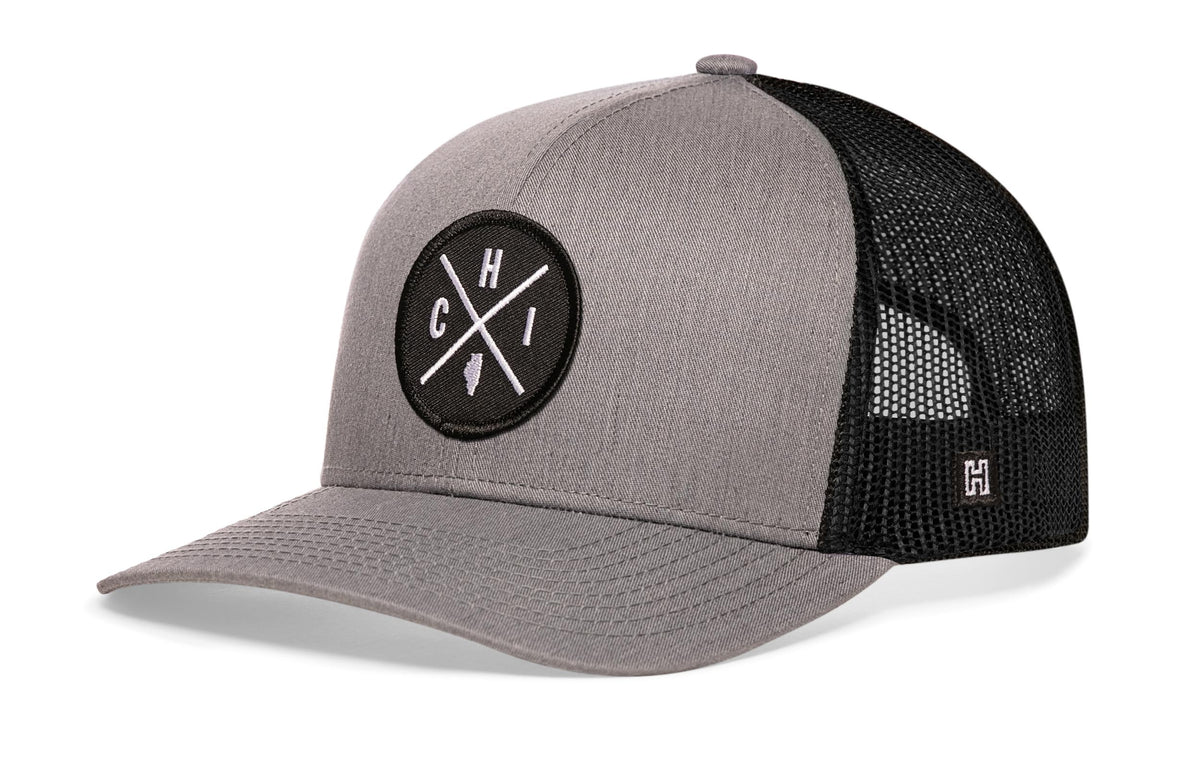 Chicago Trucker Hat, gray-black snapback showing Haka brandmark on left side of cap.