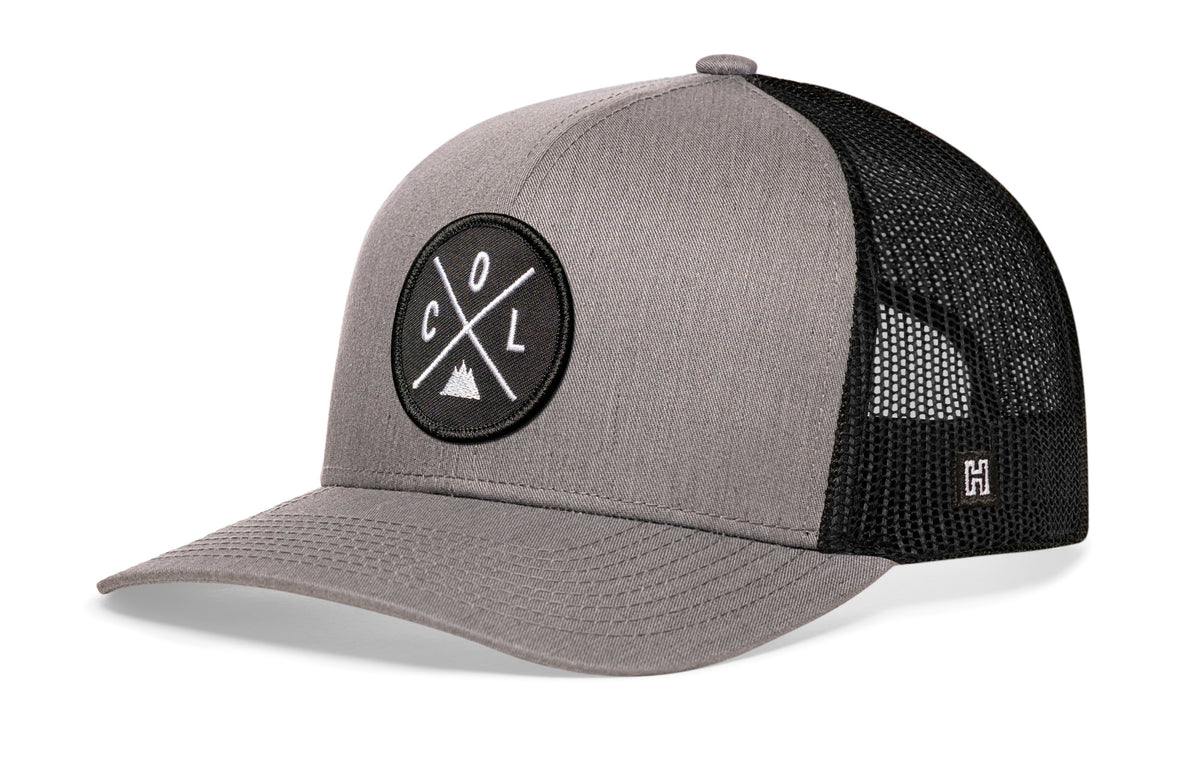Colorado Trucker Hat, gray-black snapback showing Haka brandmark on left side of cap.